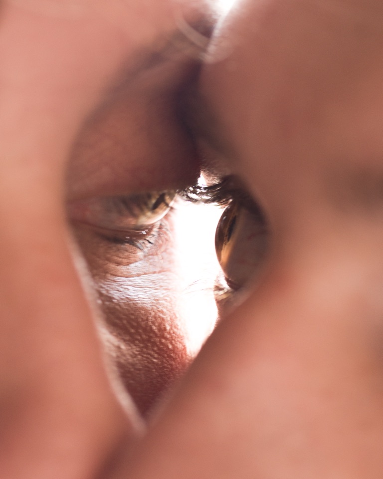 Two faces in profile almost touching, light between them