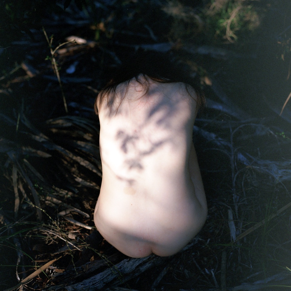 A woman's back in dark grass
