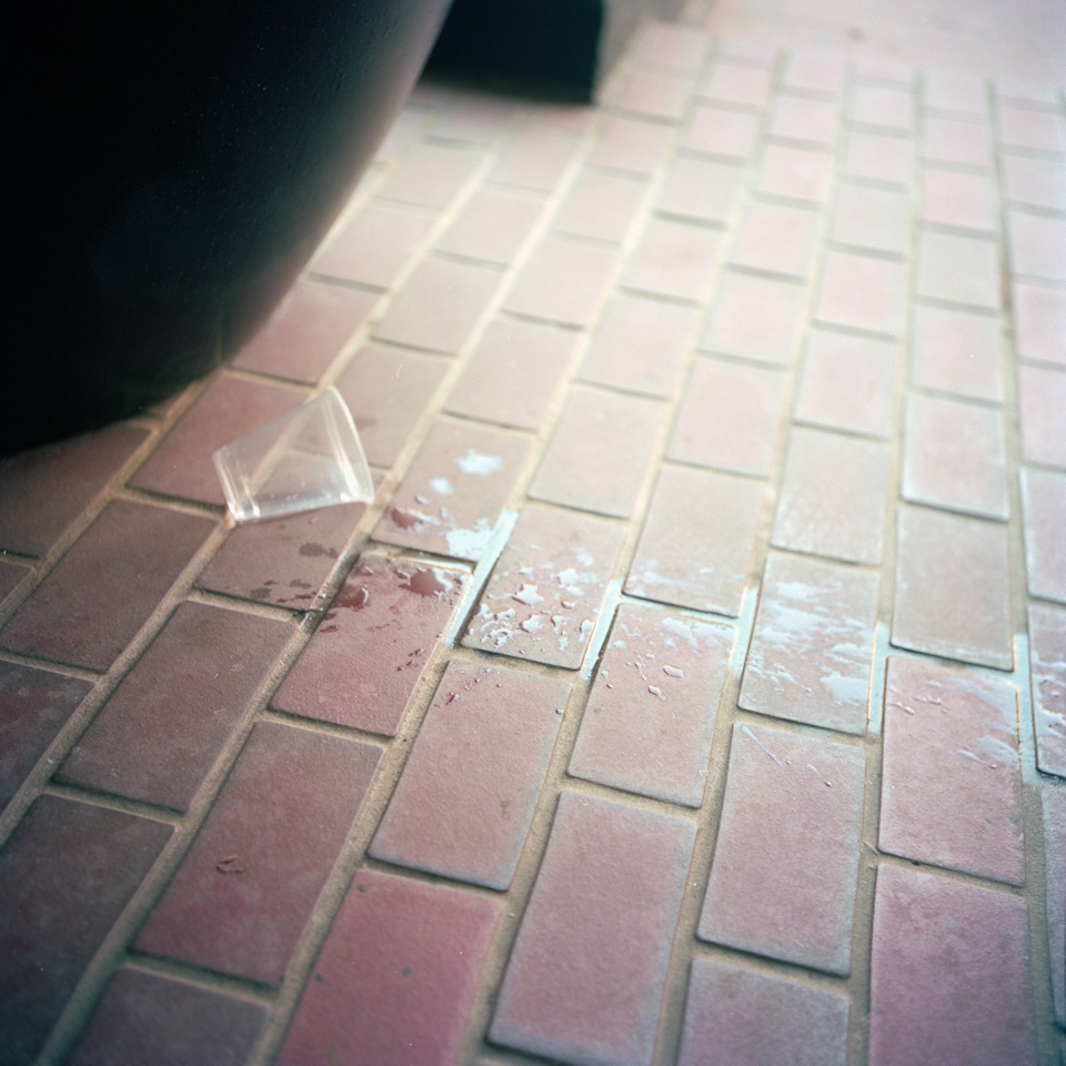 Spilled water and a broken glass on brick