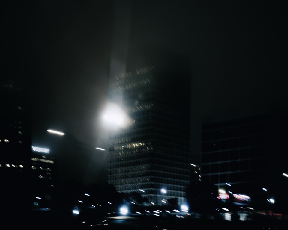 Tall buildings at night, a light flaring