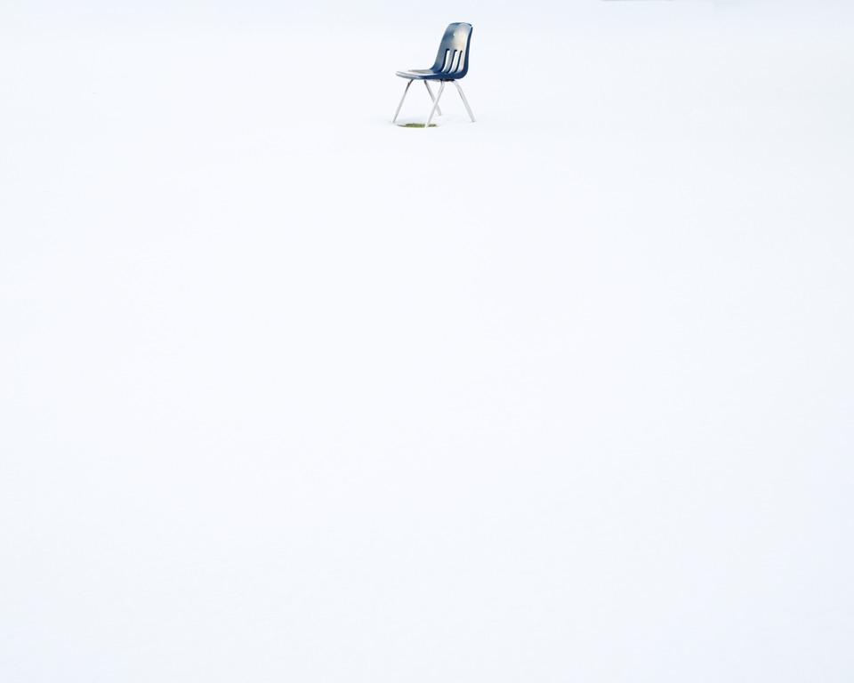 A chair alone in a field of snow